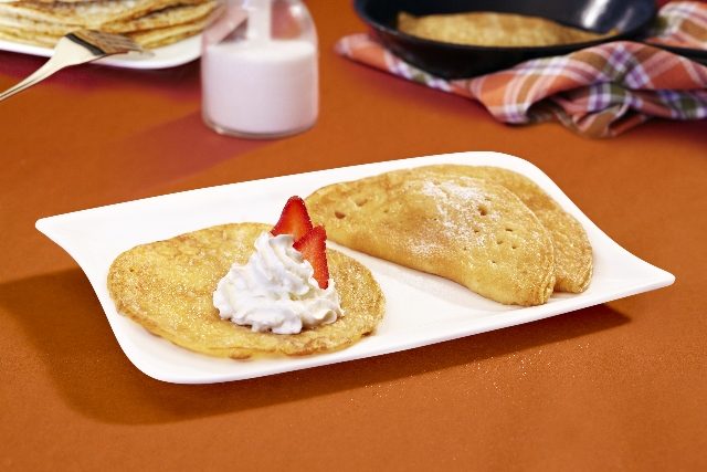 Gesüßte Eierpfannkuchen, einmal geklappt, auf einem weißen Teller